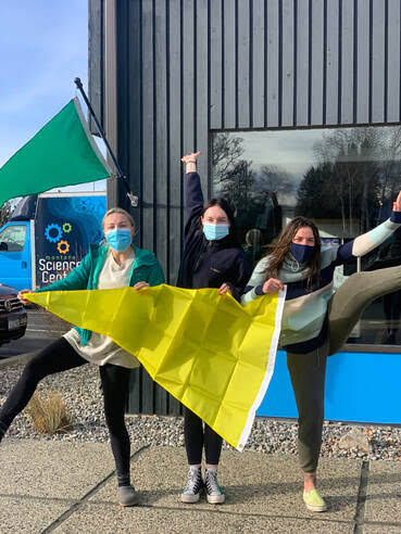 Montana Science Center holding a yellow air quality flag